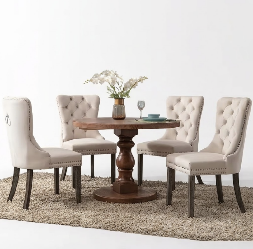 Set of 4 Upholstered Dining Chairs, Velvet Chairs with Button Tufting And Sturdy Wooden Legs, Contemporary Fabric Side Chairs for Dining Areas, Kitchens, Restaurants, And Hotels 13 A beige color Set of 4 Upholstered Dining Chairs arranged around a classic round wooden pedestal table on a textured area rug.