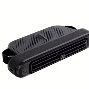 A professional product photograph featuring a black color USB powered cord portable car seat cooling fan integrated into a premium perforated leather neck support system. The hardware is displayed on a light gray surface alongside a naturally manicured hand with glossy coral-pink nails and a matte black bottle of 'NATURALL OOIL'. The fan unit is encased in a high-compliance black Napa leather chassis with micro-perforations for optimal airflow distribution. The background shows a softly blurred interior with a large window and green plant, illuminated by diffused natural daylight. All foreground elements, including the intricate leather stitching and the ergonomic U-shaped geometry, are in sharp, high-definition focus.