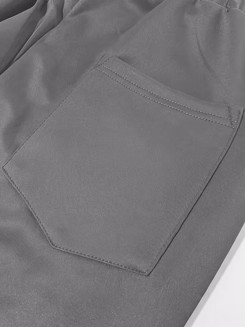 Men'S Color-Blocked Casual Pants Feature a Stylish Design with Comfortable And Structured Fabric. The Drawstring Waist Fits The Body Well, Making It Trendy And Eye-Catching. with a Loose Straight Cut 17 Detailed close-up of a structured gray rear patch pocket on loose-fit athleisure pants.