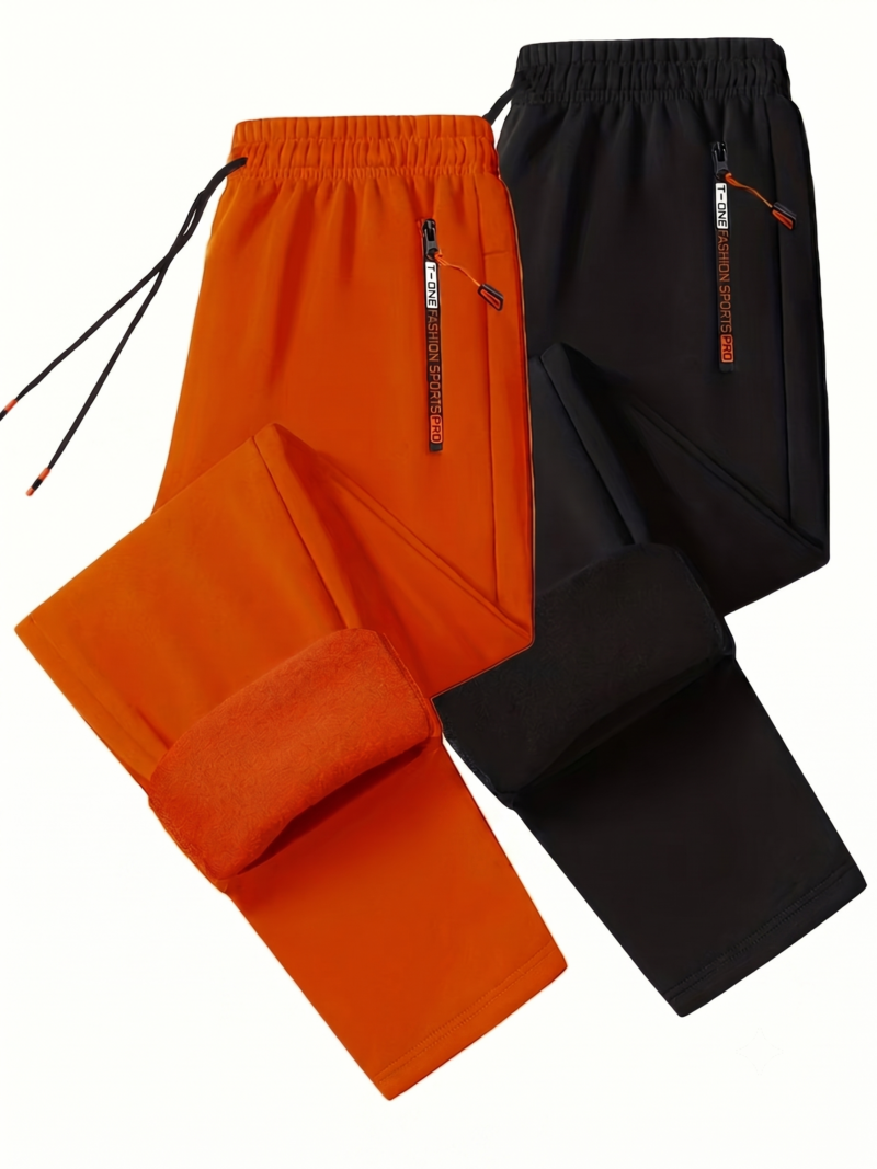 comfortable 2pcs Men's Winter Warm Fleece Sweatpants with Zipper Pockets Casual Trousers Track Pants Drawstring Waist for Running Workout Gym Outdoors for Fall Winter 13 A professional flat lay studio photograph on a white background showcasing a two piece combo set of comfortable Men's Winter Warm Fleece Track Pants, with one pair in vibrant bright orange and the other in classic solid black. The trousers are styled overlapping each other, with the lower leg segment of both pairs flipped upward to reveal the thick, insulating color matched interior thermal fleece lining.