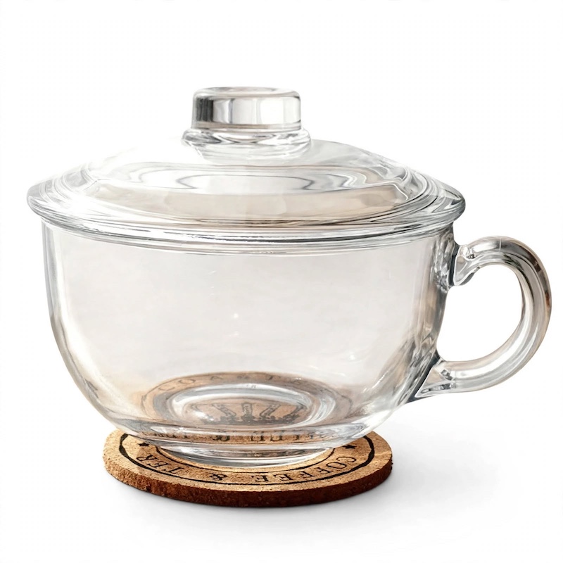 A Large-Capacity Tempered Glass Cup with a Lid And Handle, Thickened for Breakfast Oatmeal, Milk, And Suitable for Desserts, Pasta, And Rice, Microwave Safe 1 Clean front view of an empty Large-Capacity Tempered Glass Cup with its matching lid resting on a cork coaster.