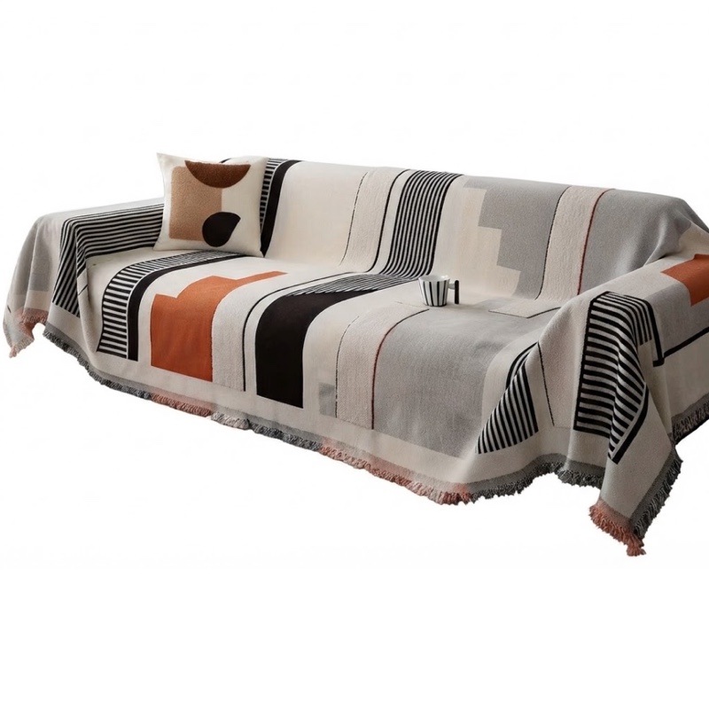 Studio front view of the geometric patterned orange color All-Season Non-Slip Sofa Cover draped over a sofa.