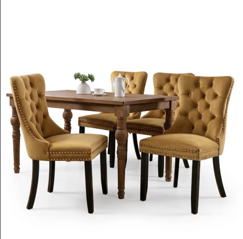 A golden color Set of 4 Upholstered Dining Chairs arranged around a rustic dark wood table in a brightly lit studio setting.
