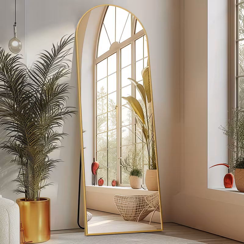 Arched Full Length Mirror with Free Standing & Leaning/Hanging Mount - Tall Vertical Oval Arch Design, Full-Body Mirror Suitable for Living Room, Bedroom, Cloakroom - Modern Simple Aluminum Frame Vertical Mirror 8 A golden color Arched Full Length Mirror with Free Standing setup placed in a cozy living room next to a metallic plant pot reflecting a sunny arched window