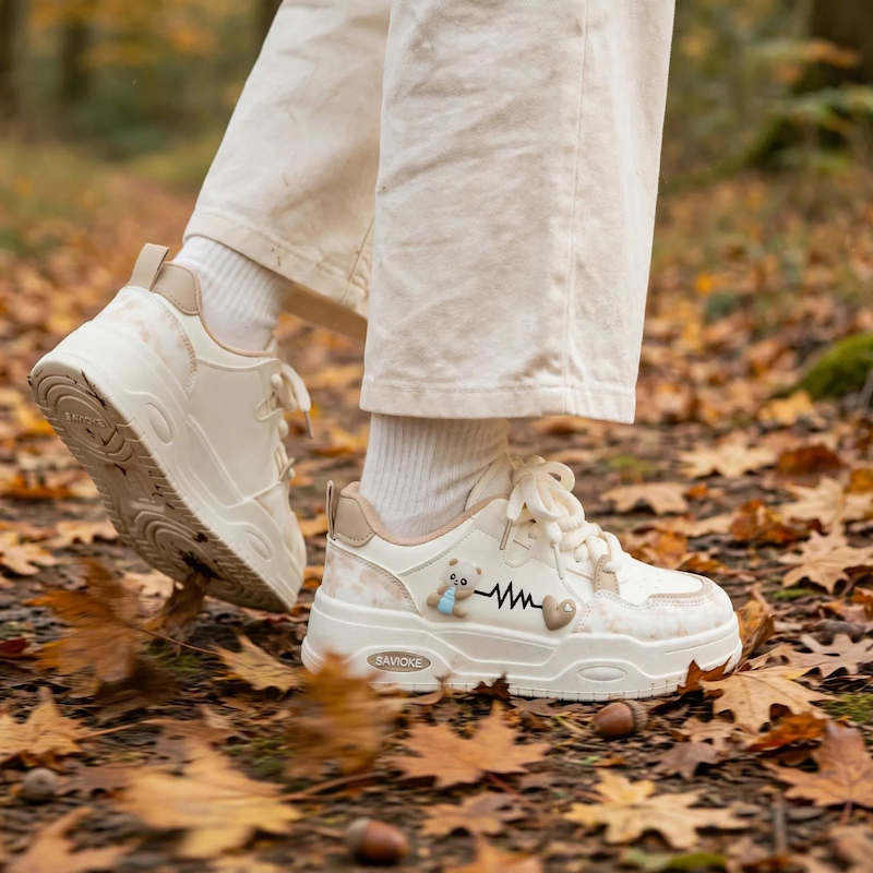 Women's White Platform Sneakers - Chunky Platform Shoes with Upper & PVC Sole, Lace-Up Mid-Top Casual Athletic Wear Suitable for Spring/Autumn, - Comfortable Footwear, Women Shoes 19 Outdoor action shot of a person wearing khaki color Women's White Platform Sneakers walking through an autumn forest path.