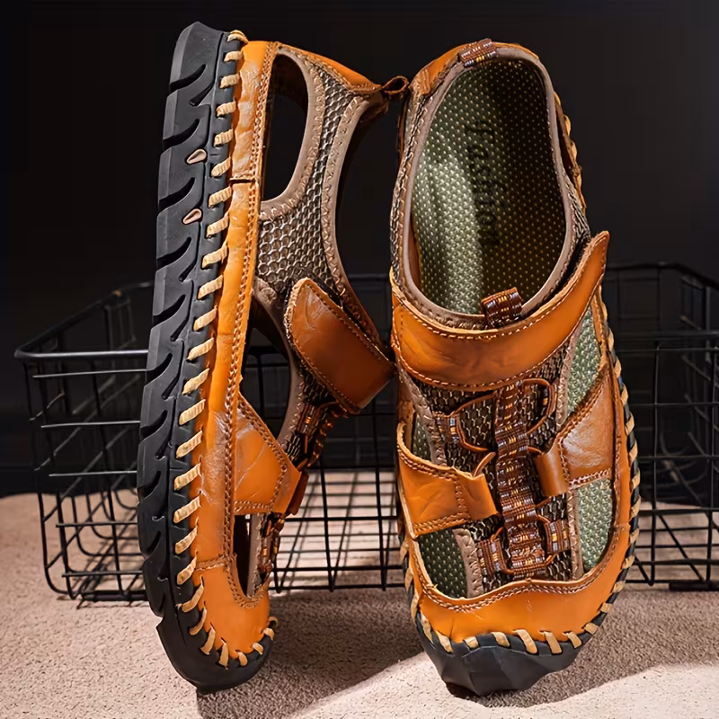 All-Terrain Casual Sports Sandals: Solid Color, Slip-Resistant Rubber Sole & Breathable Fiber Upper 12 A pair of men's closed-toe light brown color Casual Sports Sandals Solid Color standing vertically. The sandals feature a smooth upper, mesh panels for ventilation, and distinct hand-stitching details connecting the upper to a rugged black sole.