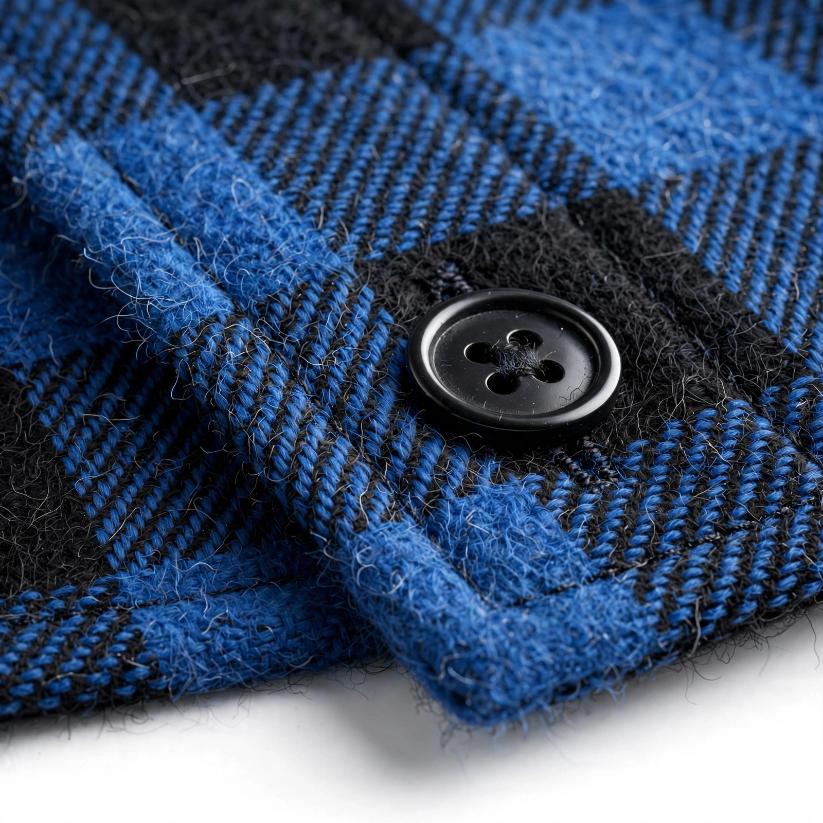 2pcs Men's New York Fashion Trendy Plaid Shirt Hoodie, Plaid Pullover Sweatshirt Flannel Hoodie 41 Close-up macro photo of a black four-hole button fastened on the blue and black flannel fabric of a fashion trendy plaid shirt hoodie.