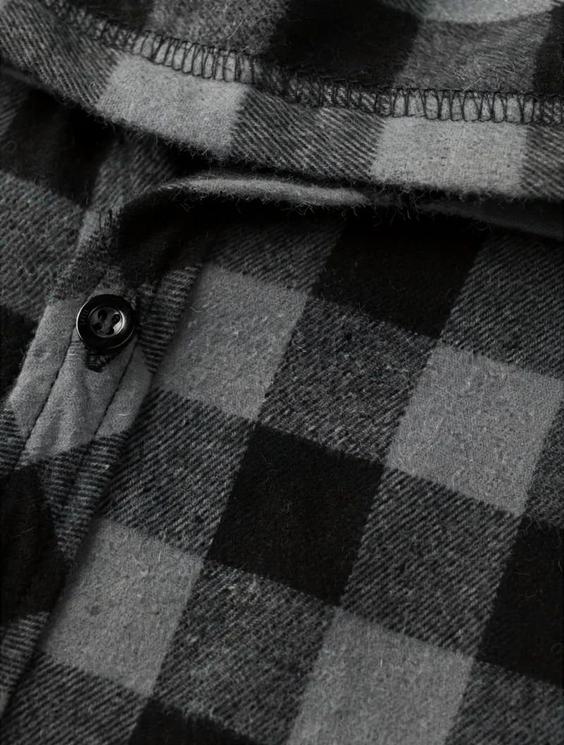 2pcs Men's New York Fashion Trendy Plaid Shirt Hoodie, Plaid Pullover Sweatshirt Flannel Hoodie 19 Close-up macro shot of the dark gray and black flannel fabric, button placket, and hood seam of a fashion trendy plaid shirt hoodie.
