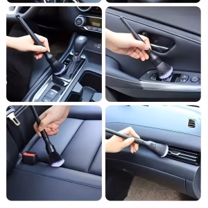 A collage of four images demonstrating the use of a black car interior detail brush with soft, grey-tipped bristles. Clockwise from top-left: cleaning the center console gear shifter area; dusting the interior door handle and power window panel; cleaning an air vent on the dashboard; and dusting deep into a leather car seat crevice near the buckle.
