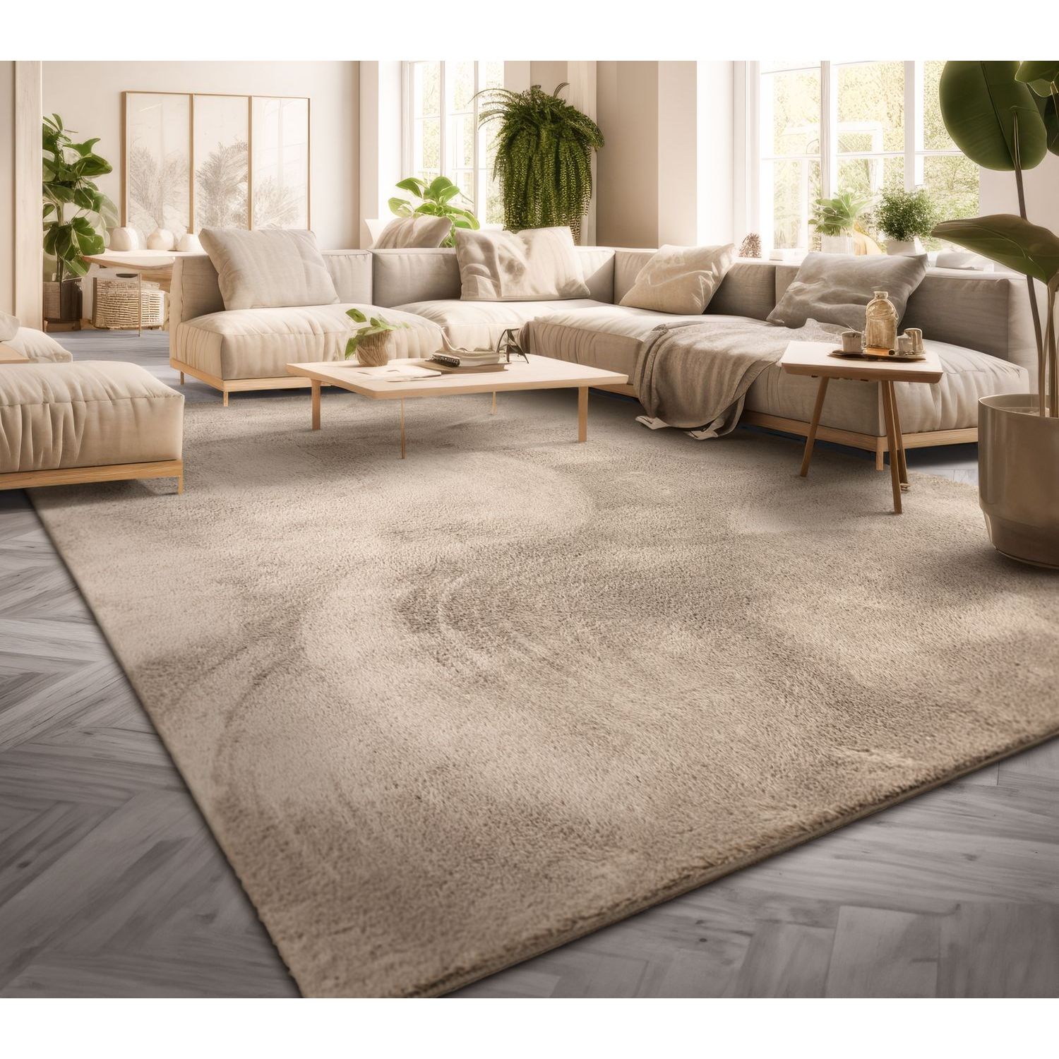 exclusive Modern Living Room Rug – Washable Short Pile Area Rug | Stain-Resistant & Non-Slip Premium Polyester 11 A large, plush beige modern living room rug laid on a gray herringbone wood floor, situated in a brightly lit room featuring a warm cream-colored sectional sofa, minimalist wooden accent tables, and thriving indoor houseplants.
