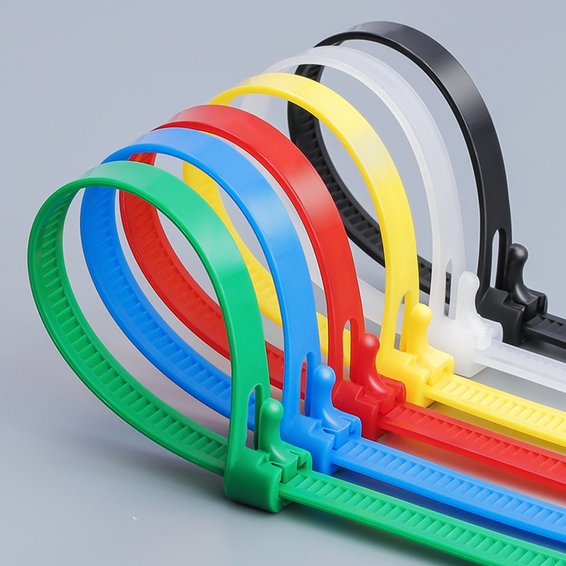 Six Plastic Reusable Cable Zip Ties in green, blue, red, yellow, white, and black colors, arranged in a row to show their adjustable locking heads and release levers.